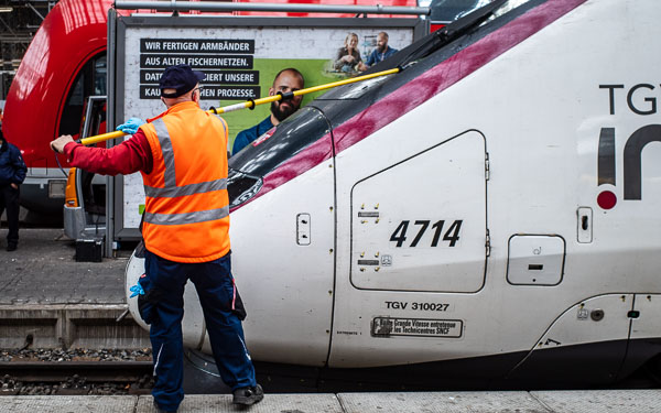 Frankfurt Hauptbahnhof - Deutsche Bahn worker cleans TGV train windscreen.